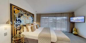 a bedroom with a large bed and a large window at Orewa Beachcomber in Orewa