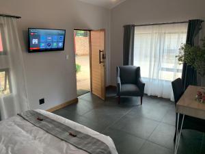 a bedroom with a bed and a tv on the wall at The Chameleon Stay @107 in Centurion