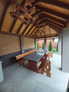 einen großen Holztisch auf einer überdachten Terrasse in der Unterkunft Садиба на Хуторі in Solotschyn