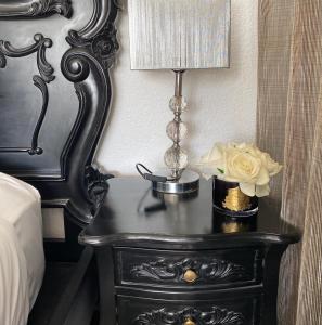 a black table with a lamp and a flower on it at Orewa Beachcomber in Orewa