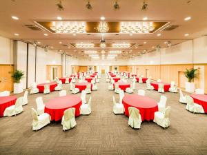 島原市にあるホテルシーサイド島原の赤いテーブルと白い椅子が備わる大宴会場