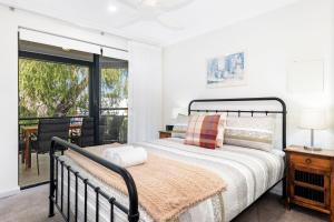 een slaapkamer met een bed en een balkon bij Escape to the Cape Villa 15 in Broadwater