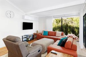 uma sala de estar com dois sofás e uma televisão em Escape to the Cape Villa 15 em Broadwater