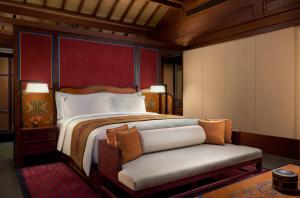 a bedroom with a large bed and a chair at Rissai Valley, a Ritz-Carlton Reserve in Jiuzhaigou