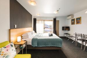 クライストチャーチにあるRoma On Riccarton Motelのベッドとテレビが備わるホテルルームです。