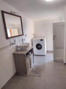 een badkamer met een wastafel en een wasmachine bij La manSarda in Tortolì