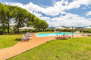 una piscina al aire libre con sillas y sombrillas en Family Apartments With Pool Near Volterra - Happy Rentals, en Pomarance