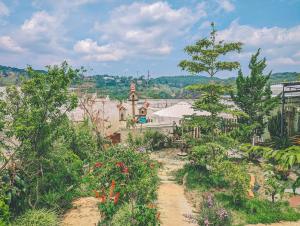 a garden with flowers and a building in the background at Lem Homestay Đà Lạt in Da Lat +22 photos