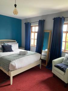 sypialnia z niebieskimi ścianami, łóżkiem i lustrem w obiekcie Ger's w Galway