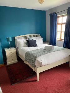 sypialnia z dużym łóżkiem z niebieską ścianą w obiekcie Ger's w Galway