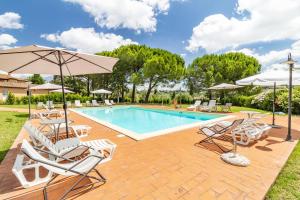 una piscina con sillas y sombrillas en Family Apartments With Pool Near Volterra - Happy Rentals, en Pomarance