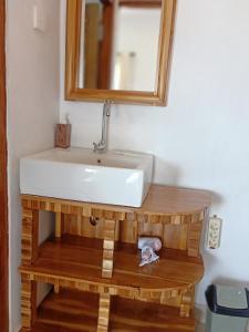 y baño con lavabo blanco y espejo. en Gamat Garden Homestay en Nusa Penida