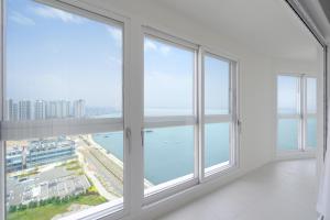 an empty room with large windows overlooking the water at Le collective Siheung Wavepark in Siheung