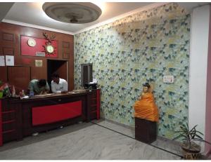 a woman in an orange sari standing in a restaurant at Hotel Mamta Palace, Kushinagar in Kushinagar