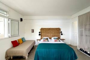 ein Schlafzimmer mit einem großen Bett und zwei Fenstern in der Unterkunft La Belle Vue - Grand studio vues mer et accès plages in Deshaies