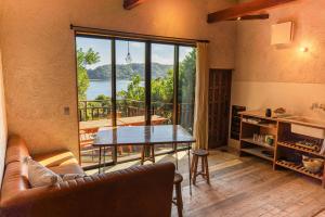 a living room with a table and a large window at Villa Yumigahama in Minamiizu