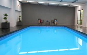 a large swimming pool with blue water in a building at Farm House in Johanna
