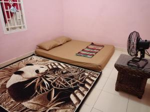 een slaapkamer met een bed en een pandabeer op een tapijt bij AL IZZAM HOMESTAY in Pagaralam
