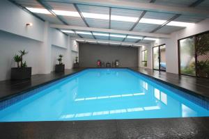 a large swimming pool with blue water in a building at Glen View in Johanna