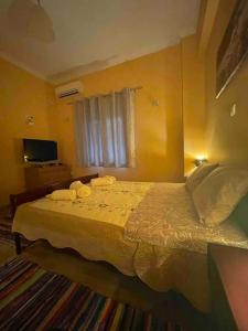 een slaapkamer met een bed met handdoeken erop bij Mary's Rainbow Apartment in Athene