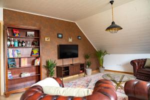 uma sala de estar com um sofá e uma televisão em Große Ferienoase mit Burgbergblick (ideal für Familien) em Bevern