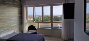 a bedroom with a large window with a view of a pool at Hotel Montemar in Noja
