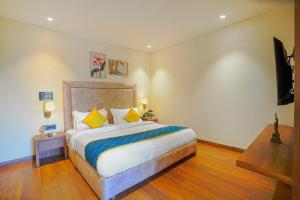 a bedroom with a large bed and a flat screen tv at Hotel Escala By Levelup in Amritsar