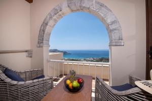 a table with a bowl of fruit on a balcony at Stefanos Village Hotel in Plakias