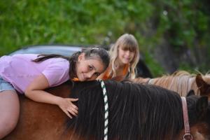 due ragazze che cavalcano dietro un cavallo di Ciasa Pedaga a San Vigilio Di Marebbe