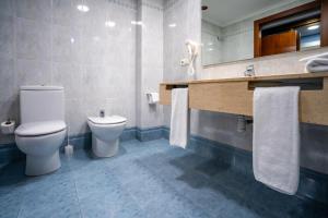 a bathroom with a toilet and a sink at Hotel Bartos in Almussafes