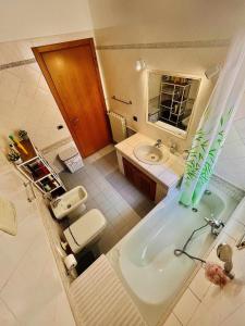 a bathroom with a tub and a toilet and a sink at casa vacanze VIVA House Sicily in Alcamo