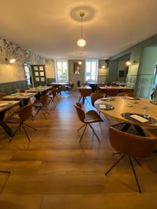 a restaurant with wooden floors and tables and chairs at Hotel Le Central in Boussac