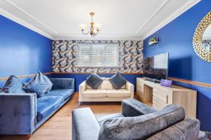 a living room with blue walls and blue furniture at Ashford Home - Spacious house close to Ashford International with ensuite and free parking in Ashford