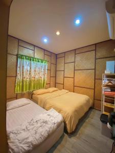 - une chambre avec 2 lits et une fenêtre dans l'établissement Chompunud House589 ชมพูนุชเฮ้าส์589, à Ban Don Klang
