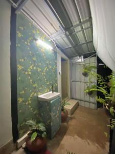 La salle de bains est pourvue d'un mur vert orné de fleurs. dans l'établissement Chompunud House589 ชมพูนุชเฮ้าส์589, à Ban Don Klang