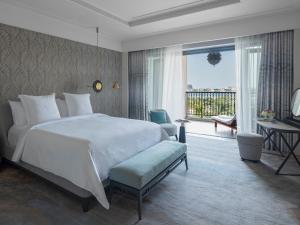 a bedroom with a large white bed and a balcony at Four Seasons Resort Dubai at Jumeirah Beach in Dubai