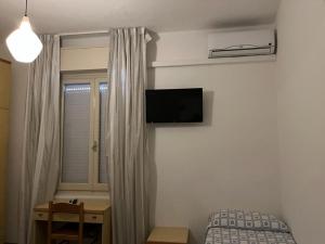 um quarto com uma cama e uma televisão na parede em Hotel Annita Cervia em Cervia