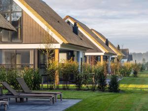 a building with two benches in front of it at Luxury villa with sauna only a few minutes from the beach in De Cocksdorp