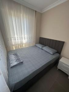 a bedroom with a large bed with a window at Zübeyde Hanım Apartmanı in Erdek
