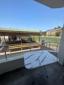 a bench sitting on a balcony with a table at Zübeyde Hanım Apartmanı in Erdek