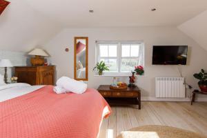 a bedroom with a bed and a tv and a window at Woodfield Wellbeing in Oving