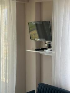 a flat screen tv sitting on a shelf next to a window at Zübeyde Hanım Apartmanı in Erdek