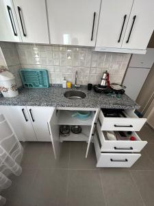 a kitchen with a sink and a counter top at Zübeyde Hanım Apartmanı in Erdek