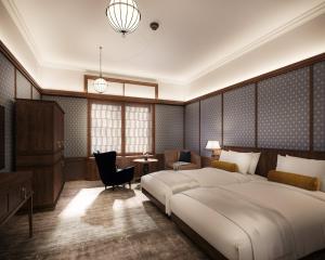 um quarto com uma grande cama branca e uma cadeira em Nikko Kanaya Hotel em Nikko
