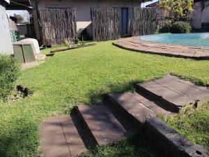 a backyard with stepping stones in the grass at The Private and Cosy Guest House 2 in Germiston