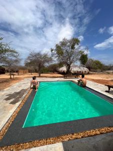 a person sitting next to a swimming pool at Yakaduru - Yala in Yala
