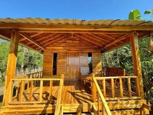a wooden cabin with a deck with a porch at Kaloka Airport Hotel in Labu Sumbawa