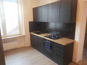 a kitchen with black cabinets and a sink and a window at Wlen Rynek II in Wleń