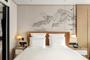 a bedroom with a white bed with two pillows at Swissotel Beijing Hong Kong Macau Center in Beijing