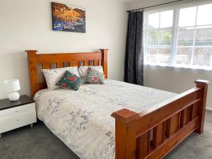 een slaapkamer met een houten bed en een raam bij Ali Motel in Auckland +34 foto's